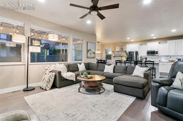 living room featuring recessed lighting, visible vents, baseboards, and wood finished floors