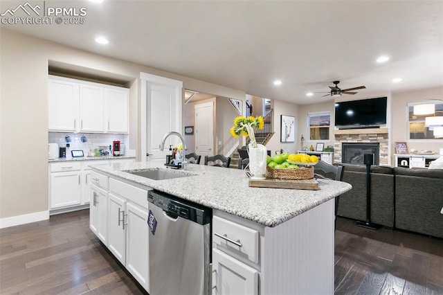 kitchen featuring an island with sink, white cabinets, stainless steel dishwasher, and open floor plan