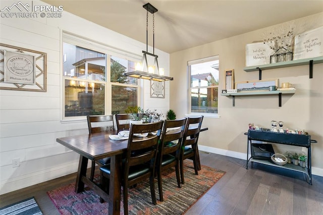 dining room with dark wood-style flooring, baseboards, and an inviting chandelier