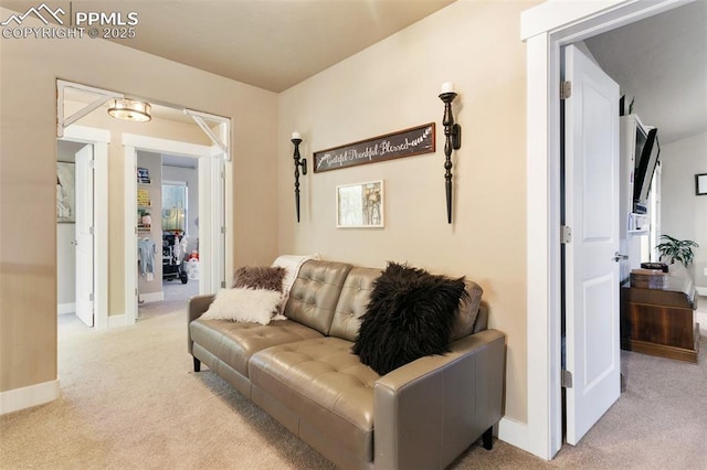 living room featuring light colored carpet and baseboards