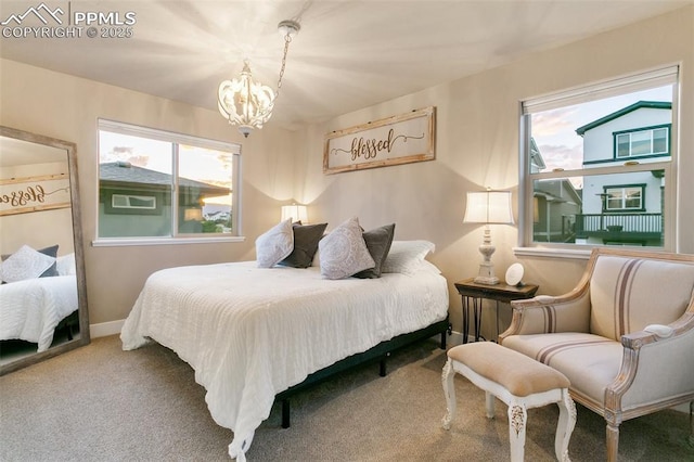 carpeted bedroom with a chandelier and baseboards