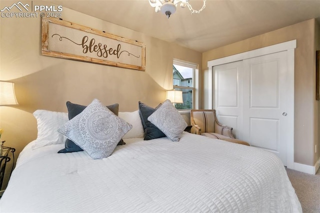 bedroom with an inviting chandelier, a closet, baseboards, and carpet flooring