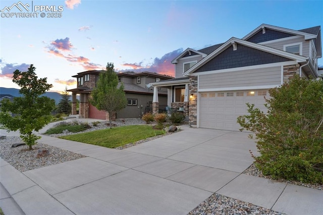 craftsman-style house featuring a garage, stone siding, and concrete driveway