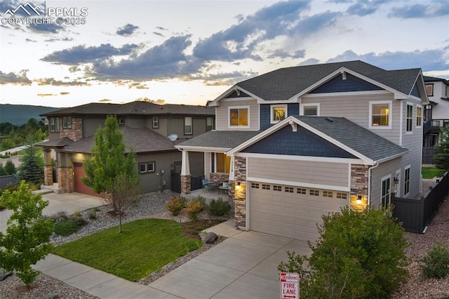 craftsman house with stone siding, an attached garage, and driveway