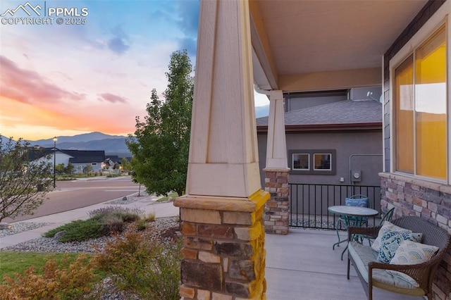 patio terrace at dusk with covered porch and a mountain view