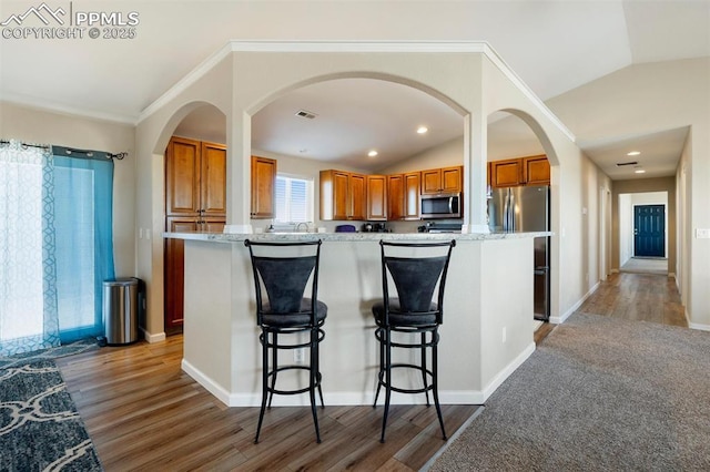 kitchen featuring lofted ceiling, appliances with stainless steel finishes, visible vents, and a center island