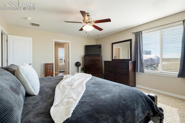 carpeted bedroom featuring baseboards, visible vents, ceiling fan, and connected bathroom