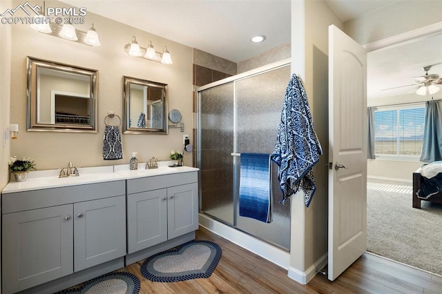 full bathroom with a stall shower, a sink, and wood finished floors