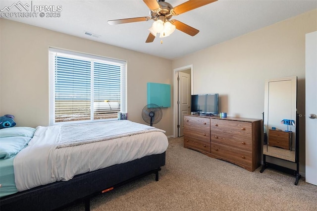 bedroom with light carpet, ceiling fan, and visible vents