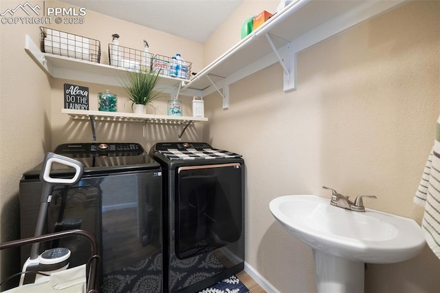 laundry area with a sink, laundry area, baseboards, and washer and dryer