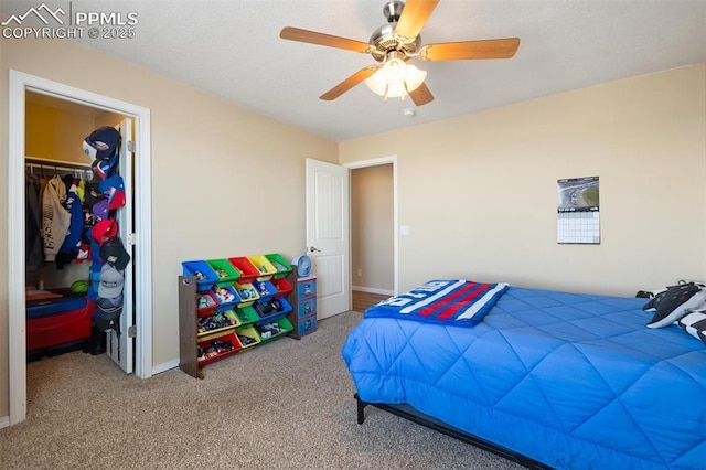 bedroom featuring a closet, carpet, a walk in closet, and baseboards