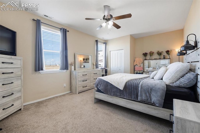 bedroom featuring baseboards, visible vents, a ceiling fan, light colored carpet, and a closet