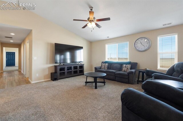 living room featuring baseboards, visible vents, a ceiling fan, light colored carpet, and vaulted ceiling