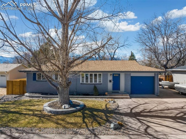 ranch-style house featuring driveway, an attached garage, fence, and roof with shingles