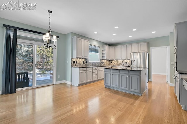 kitchen featuring dark countertops, gray cabinets, and stainless steel refrigerator with ice dispenser