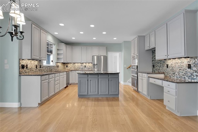 kitchen with stainless steel appliances, a center island, decorative light fixtures, and gray cabinetry