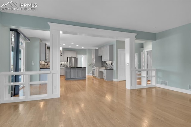 unfurnished living room featuring recessed lighting, visible vents, light wood-style flooring, and baseboards