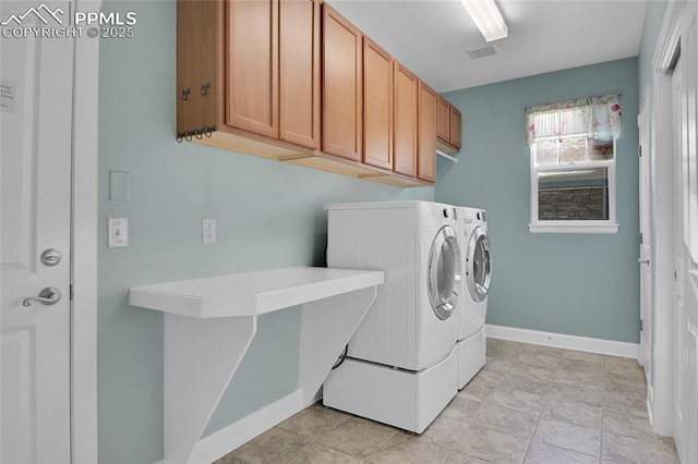 washroom featuring cabinet space, baseboards, visible vents, and washer and dryer