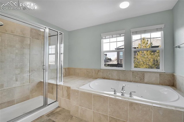 bathroom with a stall shower and a garden tub