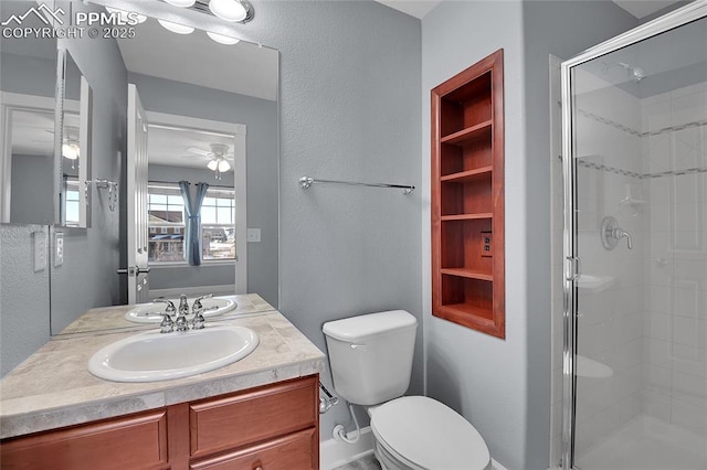 bathroom with ceiling fan, vanity, a shower stall, and toilet