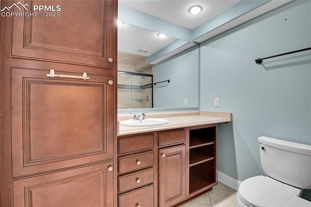 full bathroom with toilet, a tile shower, vanity, baseboards, and tile patterned floors