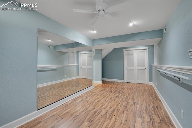 additional living space with light wood-style flooring, visible vents, baseboards, and ceiling fan