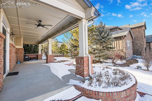 snow covered patio with a hot tub and a ceiling fan