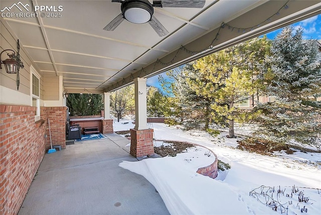 snow covered patio with a hot tub