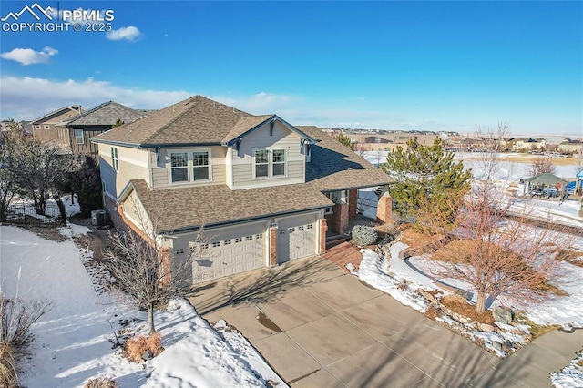 traditional-style house with brick siding, roof with shingles, an attached garage, cooling unit, and driveway