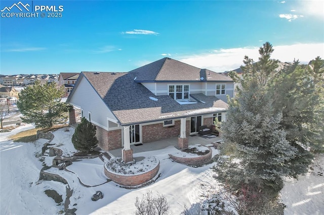 view of front of property featuring a shingled roof and brick siding