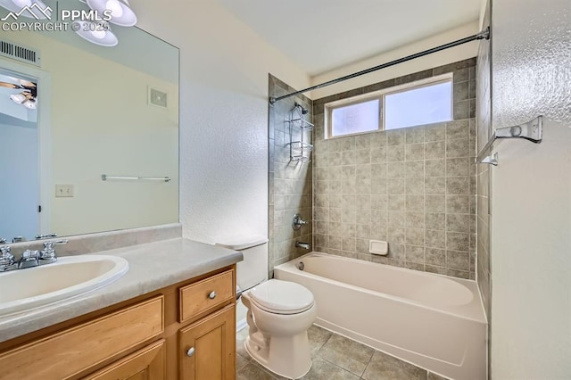 bathroom with visible vents, shower / bath combination, toilet, vanity, and tile patterned floors