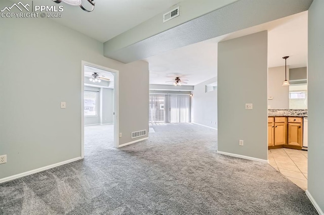 empty room featuring light carpet, baseboards, and visible vents