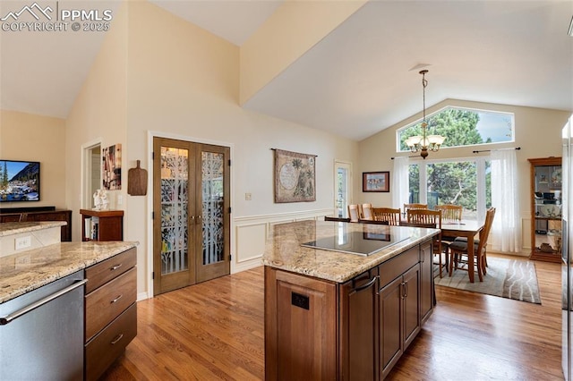 kitchen with lofted ceiling, black electric stovetop, light wood-style floors, french doors, and pendant lighting