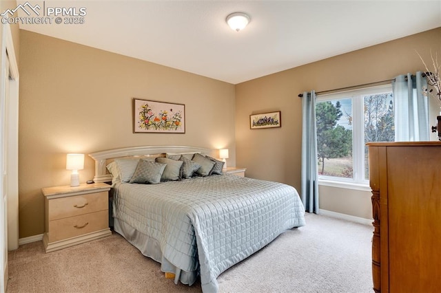 bedroom featuring light carpet and baseboards