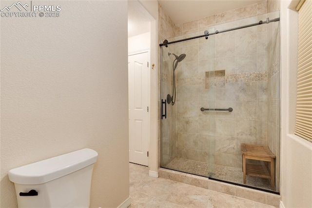 bathroom with toilet and a stall shower