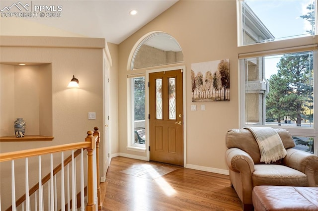 entrance foyer featuring baseboards, vaulted ceiling, wood finished floors, and recessed lighting