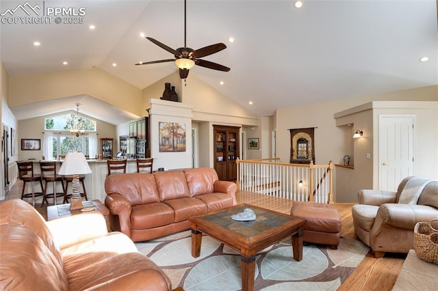 living area with high vaulted ceiling, recessed lighting, light wood-style flooring, and an inviting chandelier