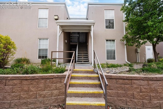 entrance to property featuring stucco siding