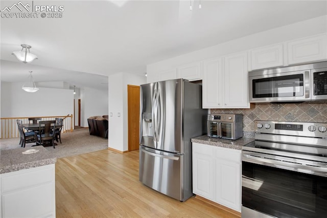 kitchen with stone countertops, white cabinetry, appliances with stainless steel finishes, light wood finished floors, and tasteful backsplash