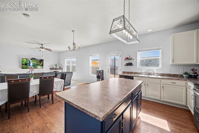 kitchen featuring a kitchen island, a sink, open floor plan, blue cabinetry, and light wood-type flooring