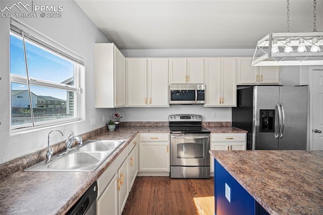 kitchen featuring dark wood-style floors, decorative light fixtures, stainless steel appliances, white cabinetry, and a sink