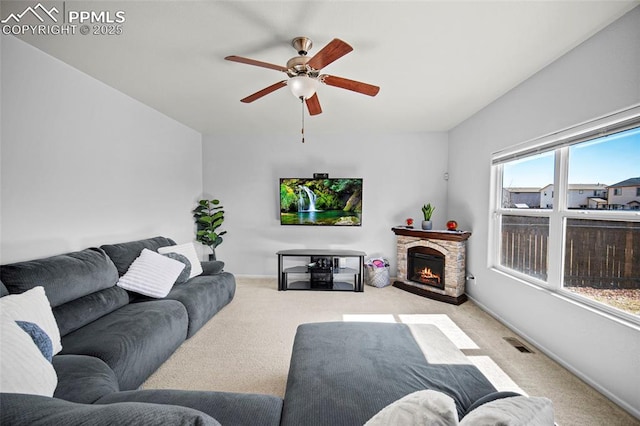 carpeted living area featuring a ceiling fan, visible vents, a fireplace, and baseboards