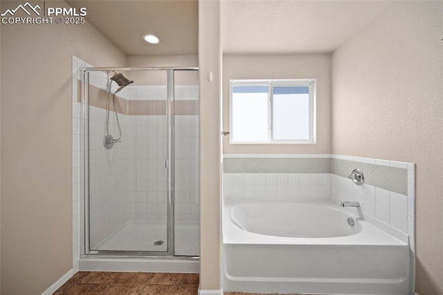 full bathroom featuring a stall shower, baseboards, and a bath