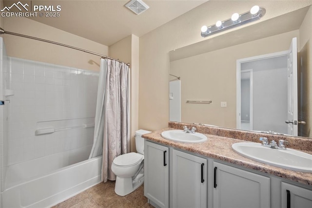 bathroom featuring visible vents, a sink, toilet, and double vanity