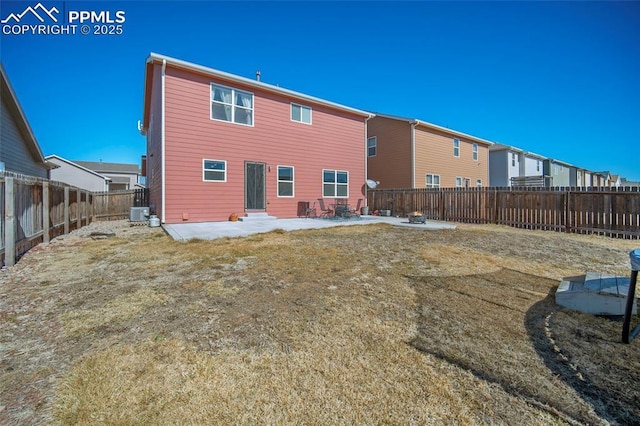 rear view of property with entry steps, a patio, a lawn, and a fenced backyard