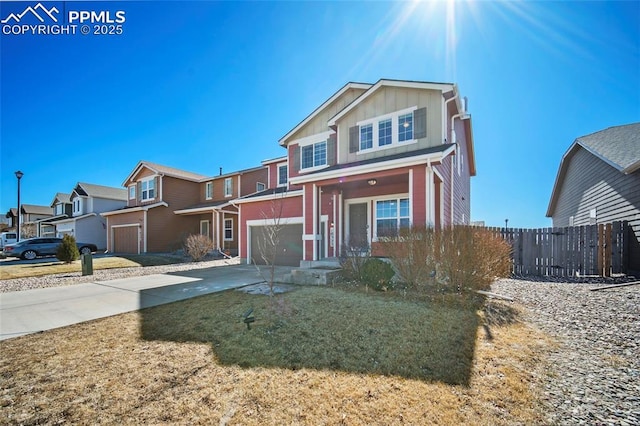 traditional-style home featuring an attached garage, board and batten siding, fence, a residential view, and driveway