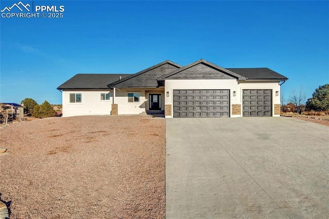 view of front of home with a garage, driveway, and stucco siding