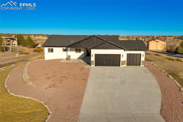 view of front facade featuring a garage, driveway, and stucco siding