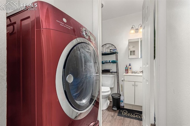 washroom featuring washer / dryer, light wood-style flooring, and laundry area