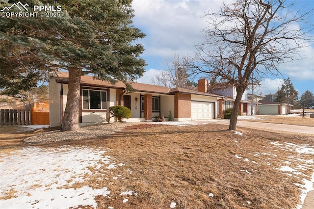 ranch-style house featuring a garage, concrete driveway, a chimney, fence, and brick siding